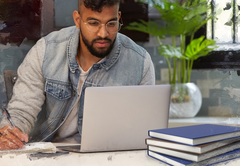 Guy reading from his computer he bought with his tertiary education loan